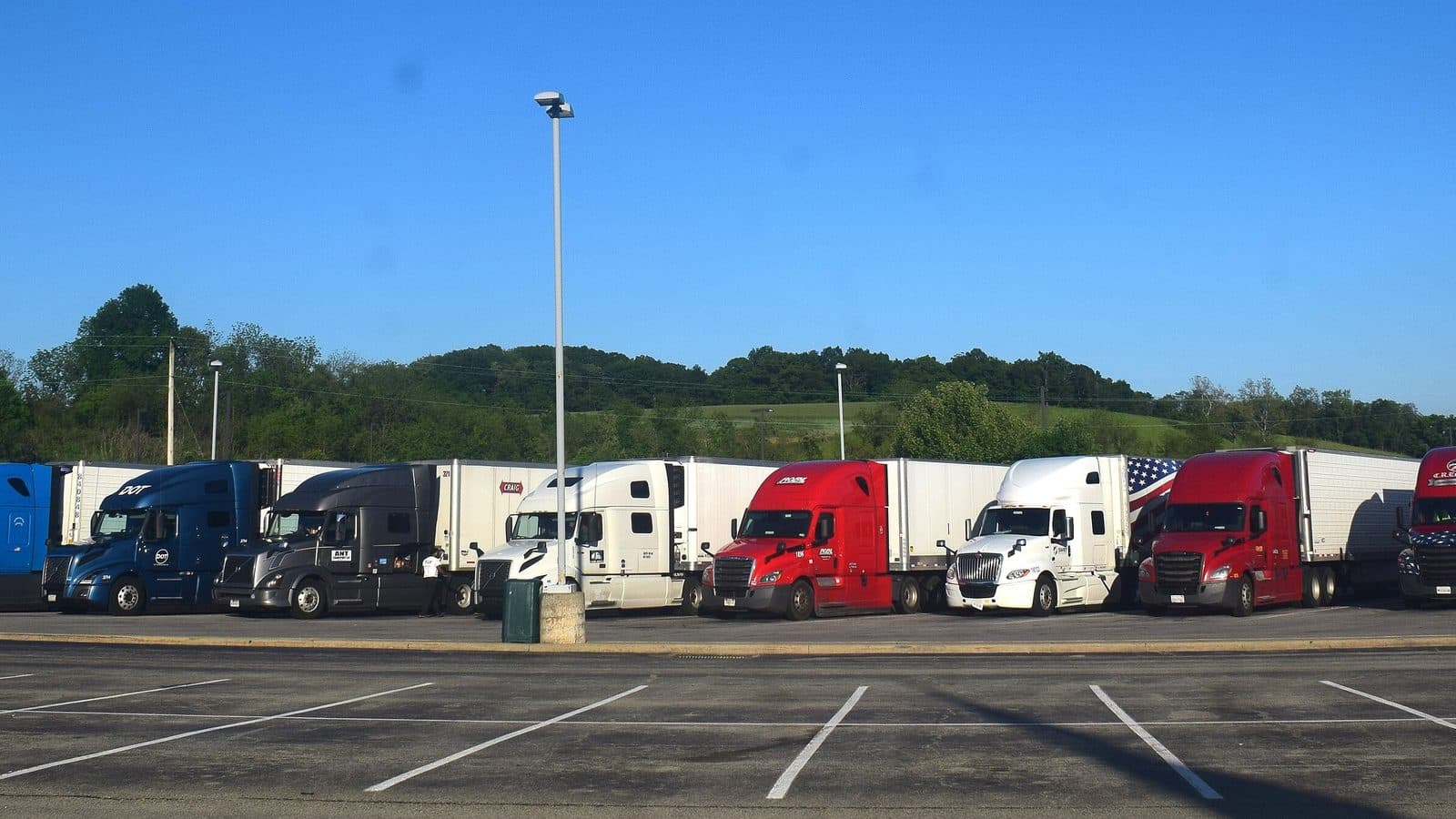 Tractor-trailers parked in a line at a highway truck stop